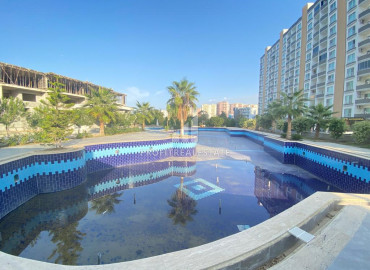 Apartment 1 + 1, 60m², in a residence with a swimming pool under construction in the Tomyuk area, Mersin ID-12133 фото-8